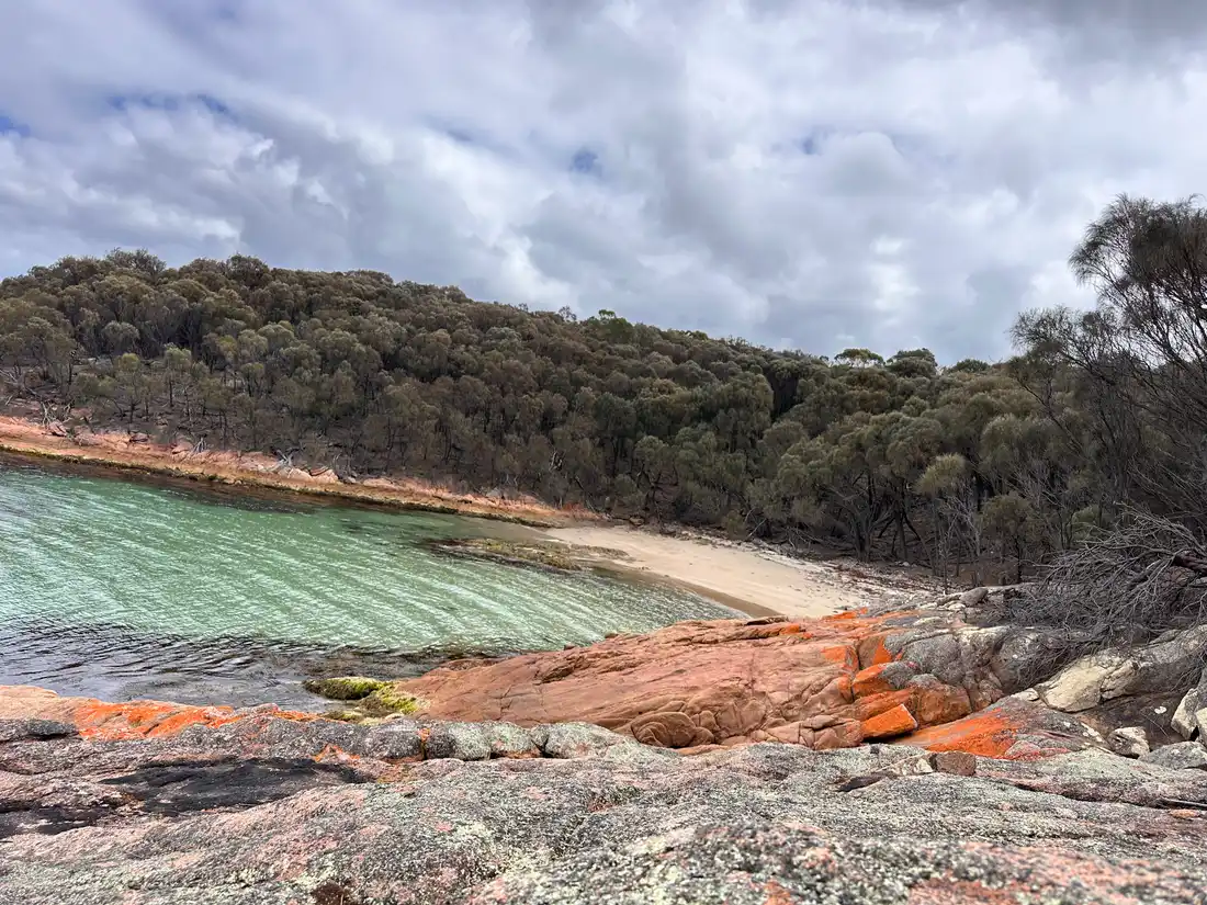 Honeymoon Bay crystal clear water over orange granite rocks