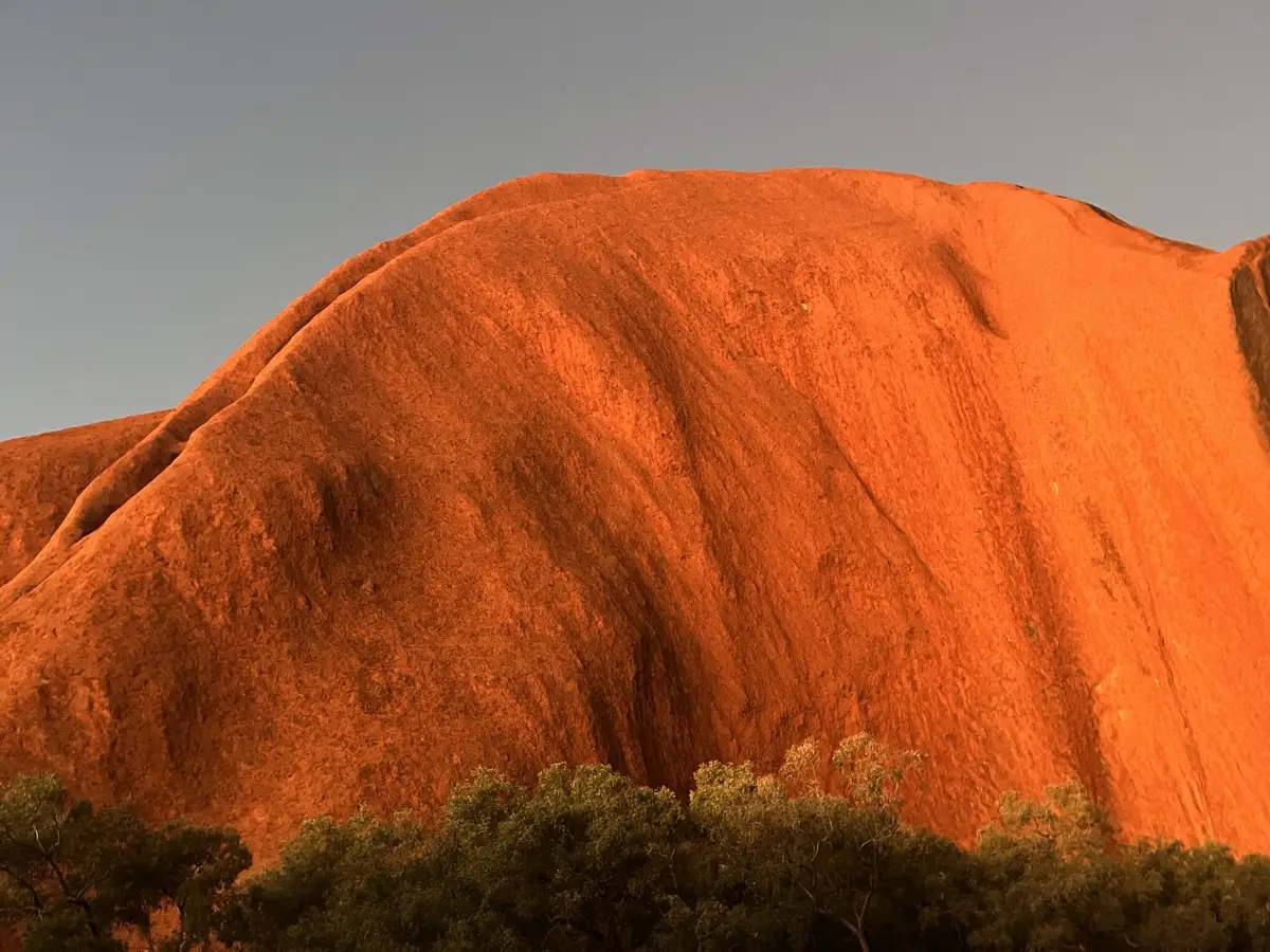 The summit of Uluru glowing deep orange-red at sunset