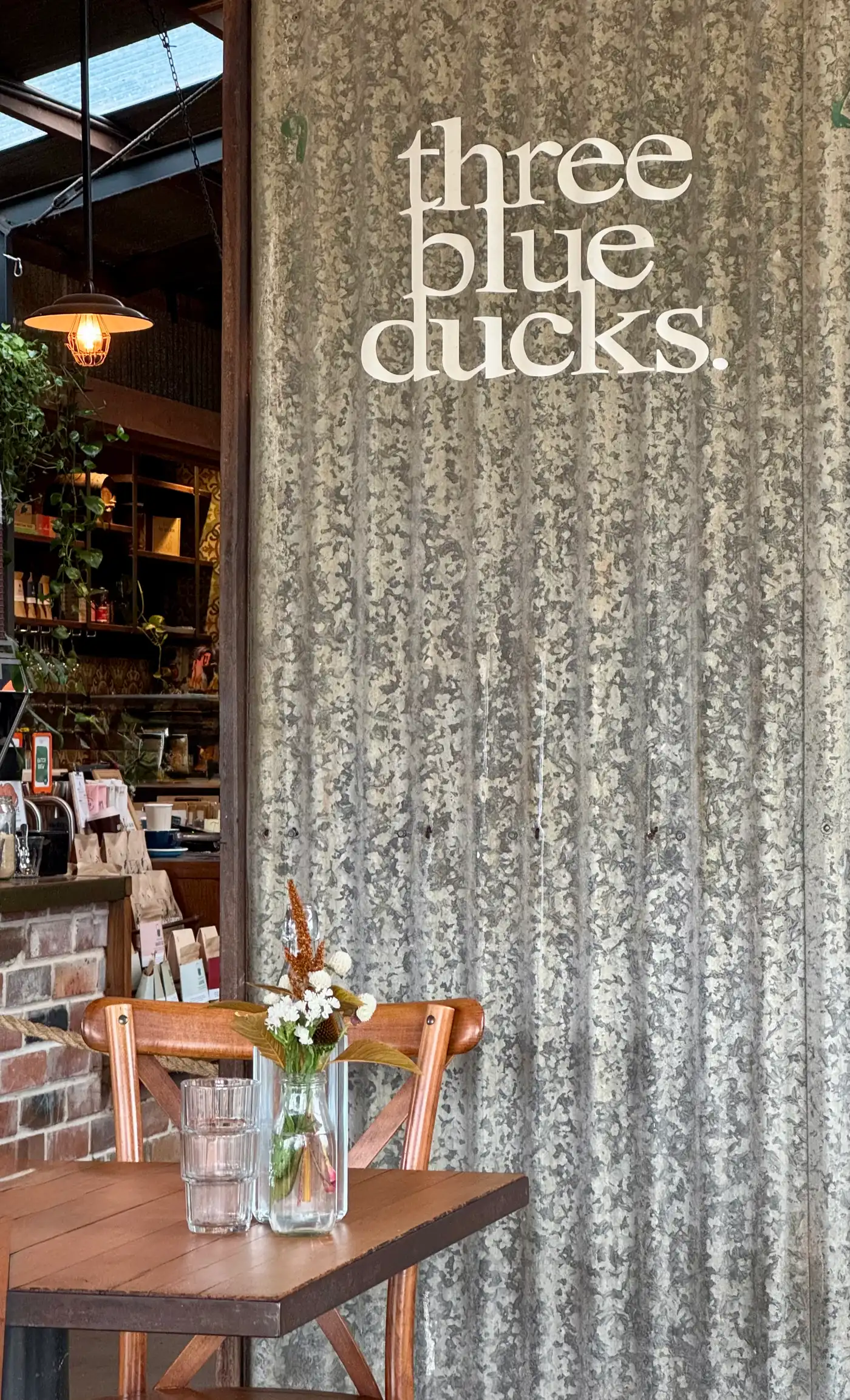 Three Blue Ducks restaurant interior at The Farm Byron Bay with corrugated iron walls and rustic dining tables